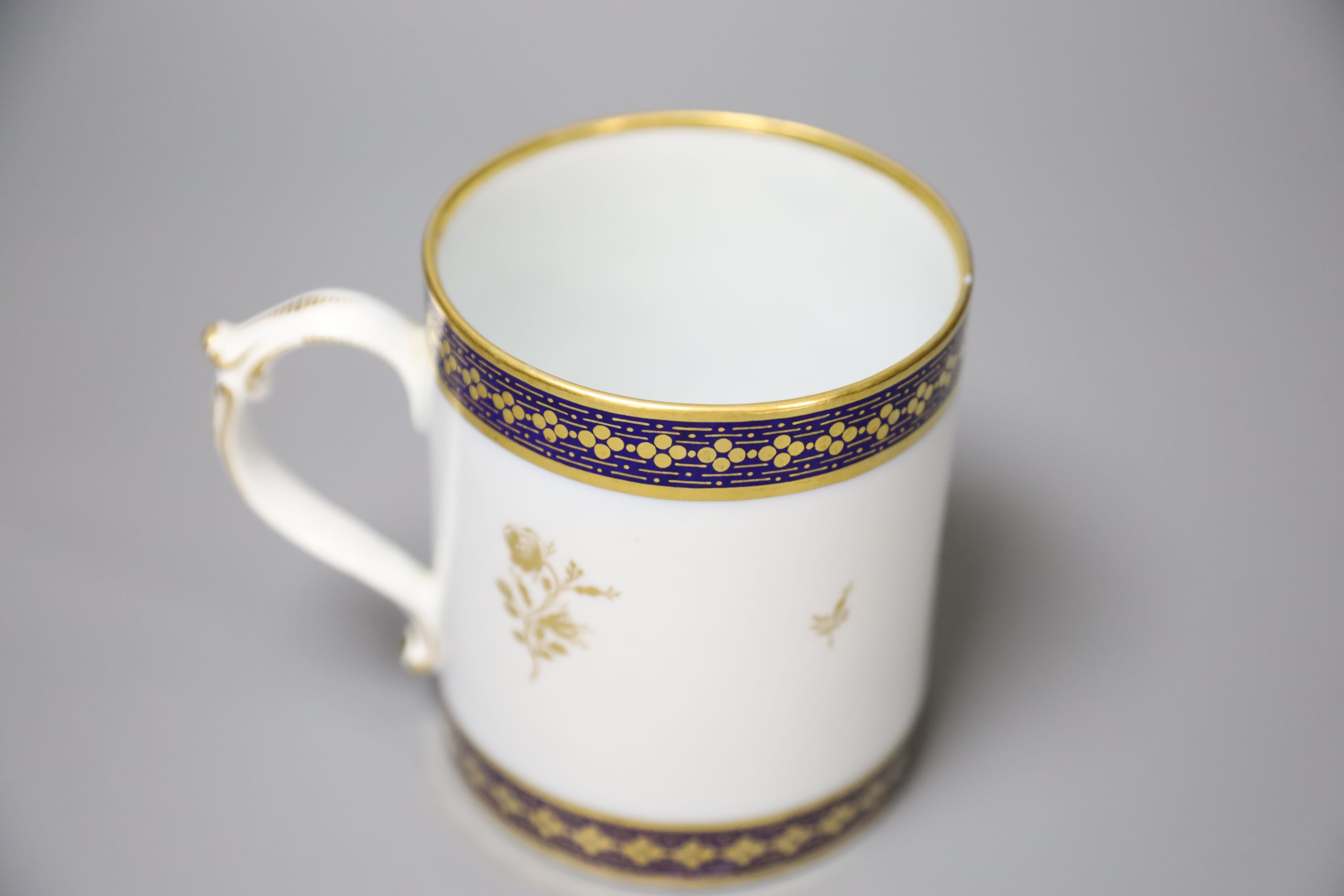 A 19th century Barr Worcester fine mug with a distinctive handle painted in under glaze blue and gilded with floral sprays, height 11cm